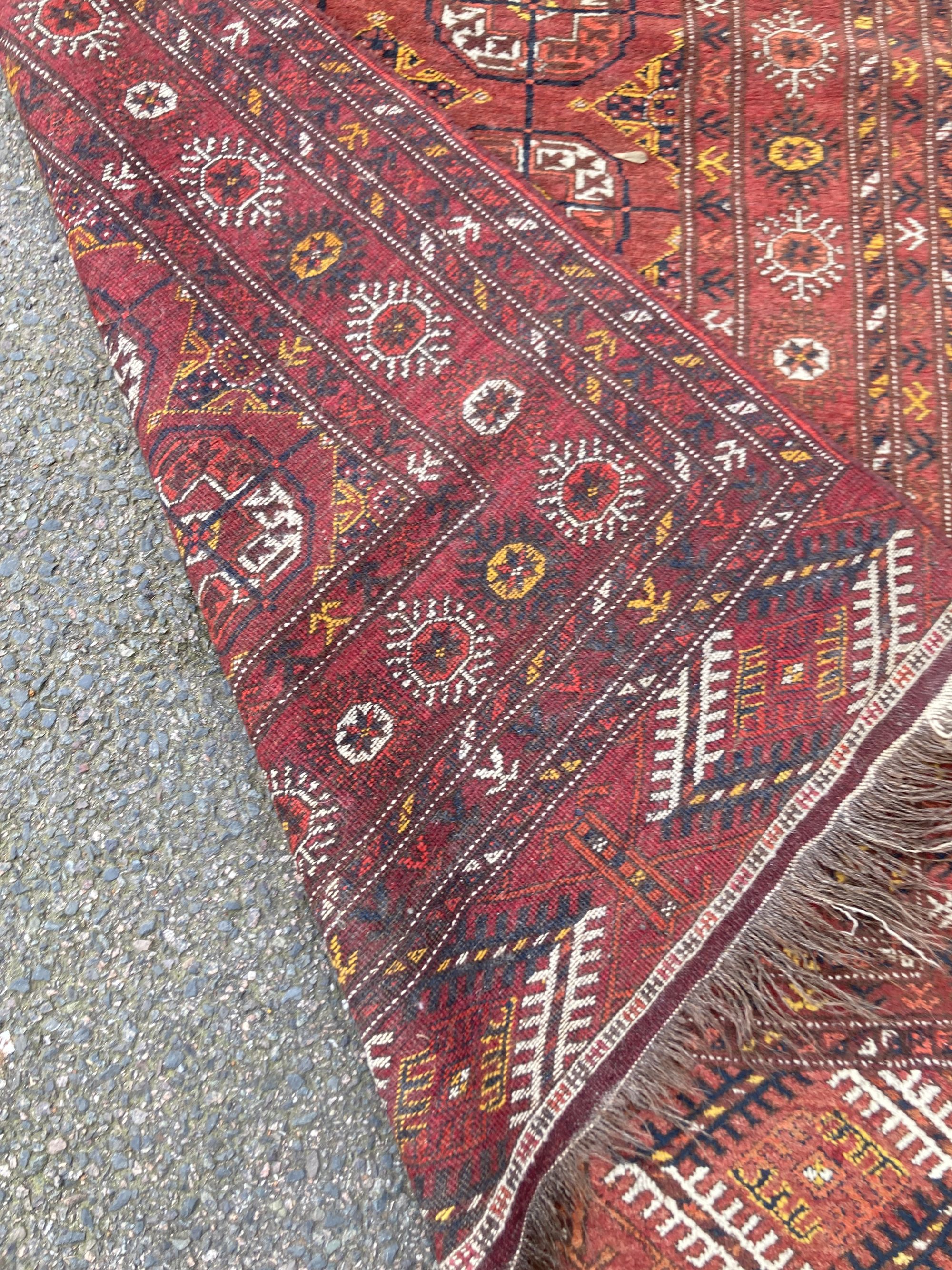 A Bokhara burgundy ground rug, 210 x 113cm